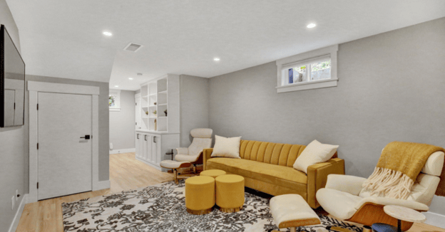 remodeled basement with yellow couches and neutral wall color