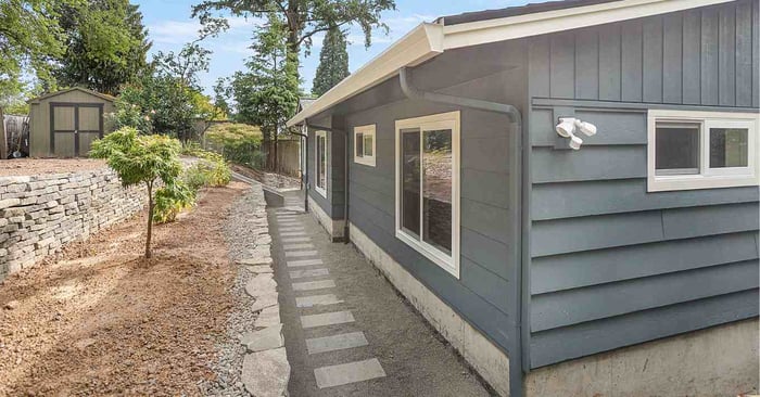 grey house with white gutters after home remodel