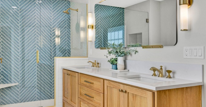 Remodeled bathroom with blue tile and wood cabinets