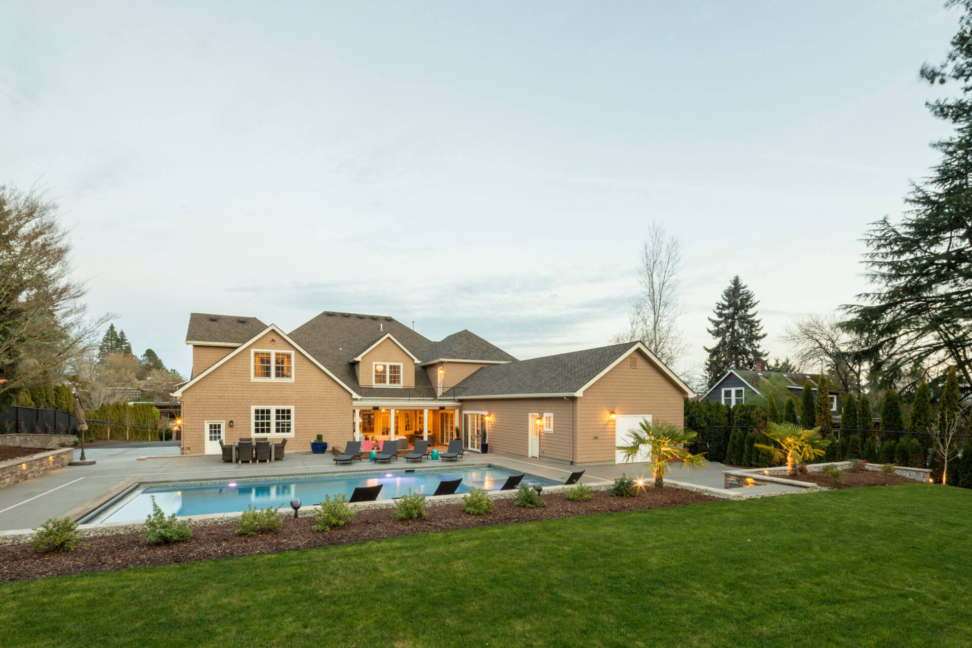 beige brick exterior home with backyard pool by cooper design build in portland oregon